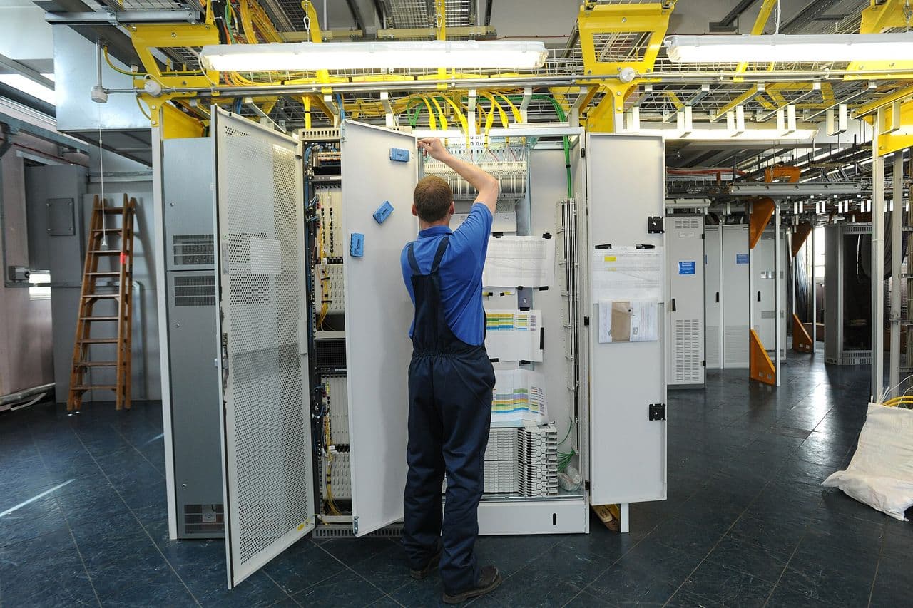 An engineer working at fibre cabinets inside a telephone exchange